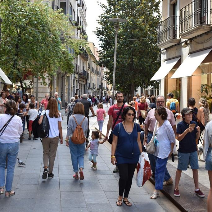 gent passejant per un carrer comercial