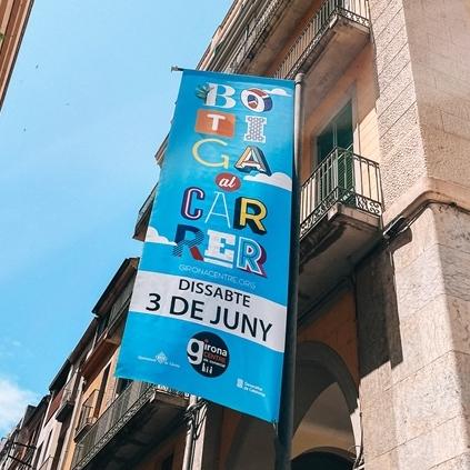 Banderola amb imatge de la campanya Botiga al carrer ubicada entre dos carrers