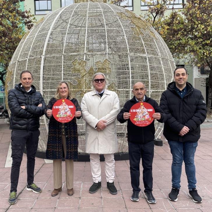 Membres de la junta de govern de Girona Centre Eix Comercial mostren la imatge de campanya, a la plaça Miquel Santaló.