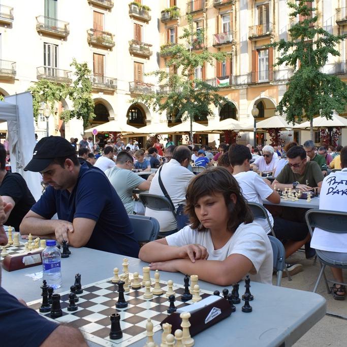 Gent jugant a escacs en una plaça