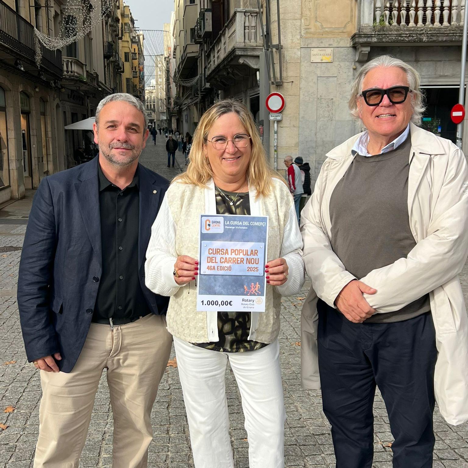 Els representants de Girona Centre Eix Comercial i el Rotary Club mostren el xec solidari