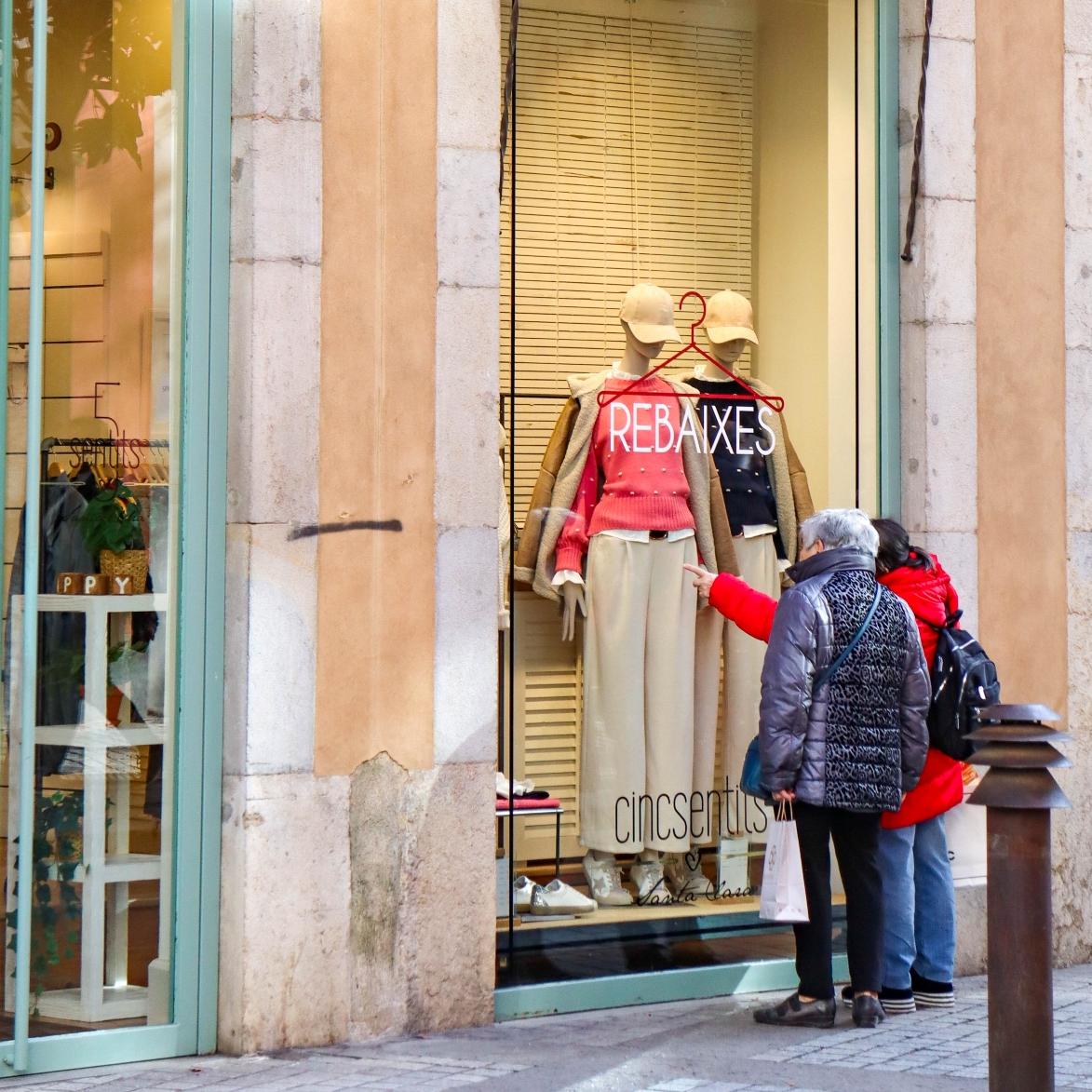 Persones mirant un aparador en rebaixes