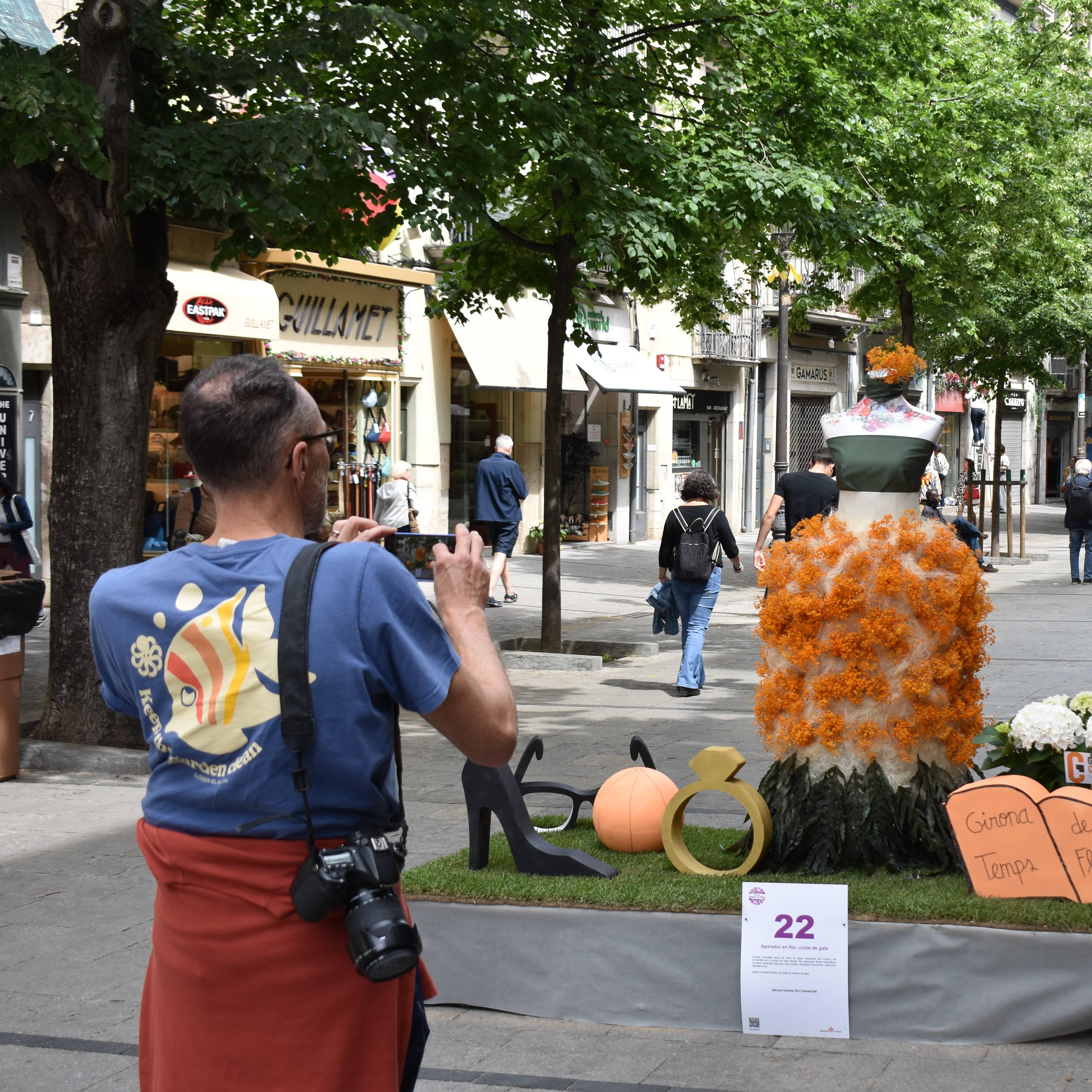 Muntatge Tempsd e Flors a la Rambla. Un visitant hi fa una foto.