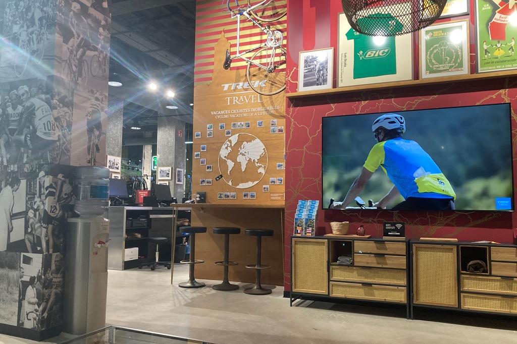 Un espai de la botiga, amb una televisió en què es veu un ciclista