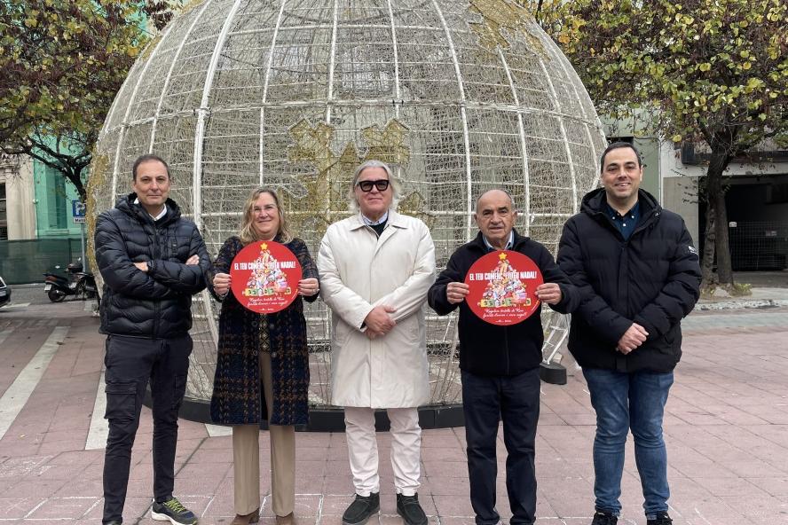 Membres de la junta de govern de Girona Centre Eix Comercial mostren la imatge de campanya, a la plaça Miquel Santaló.