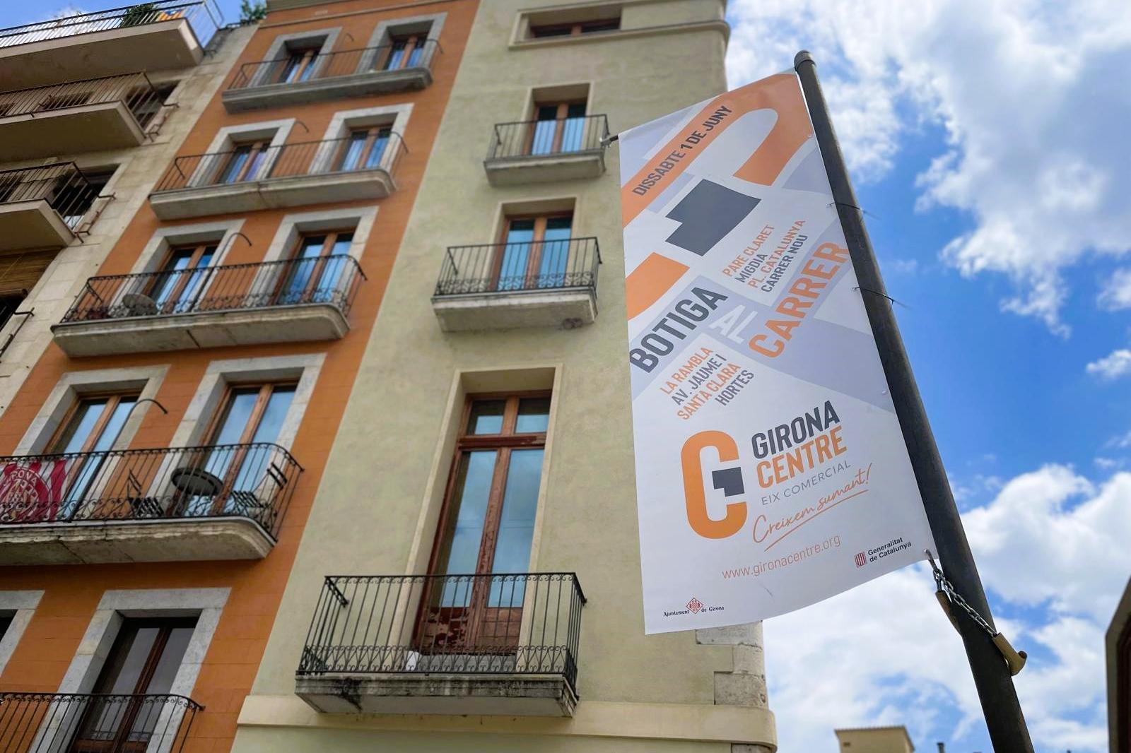 Banderola al carrer anunciant la botiga al carrer