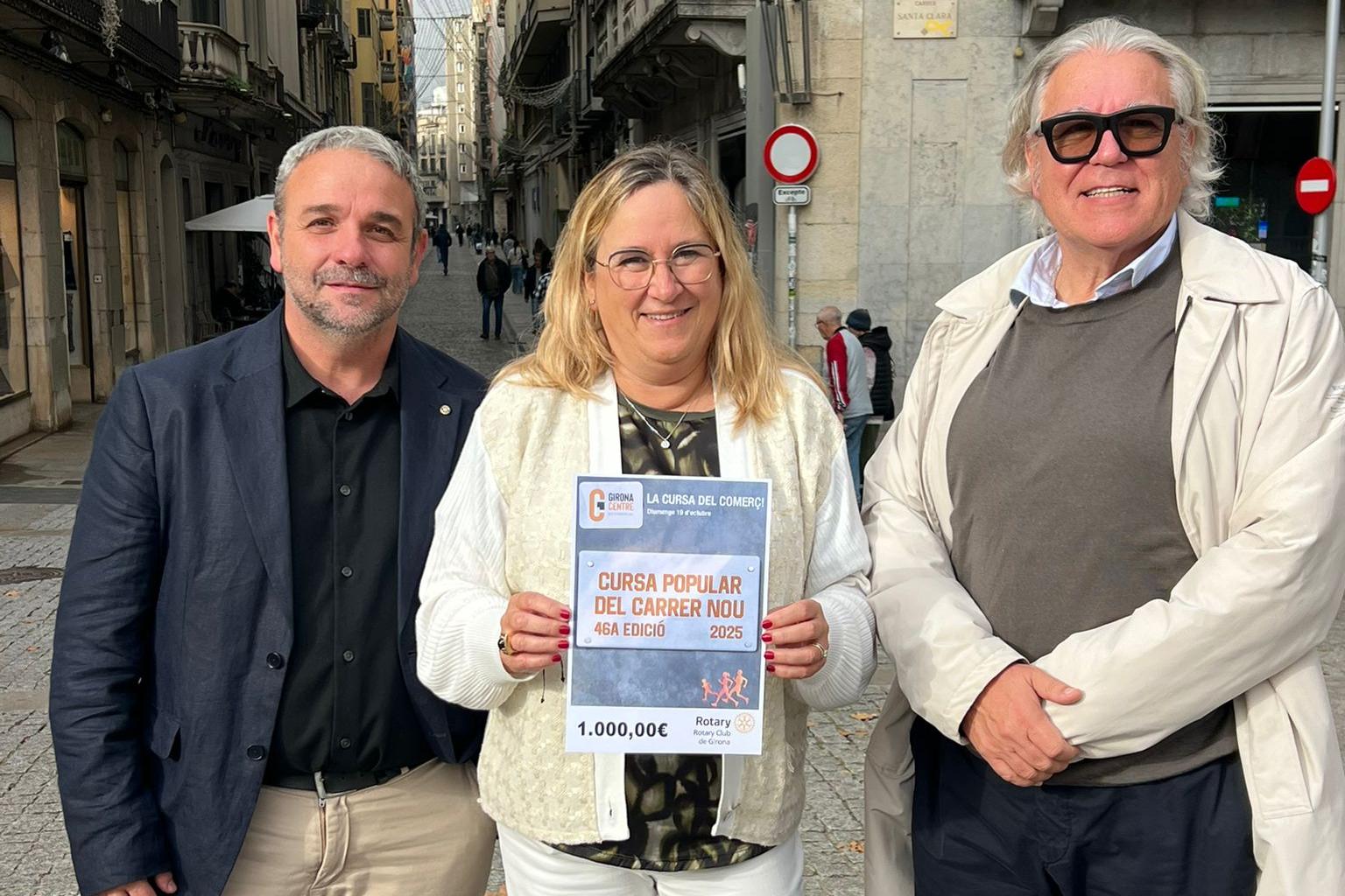 Els representants de Girona Centre Eix Comercial i el Rotary Club mostren el xec solidari