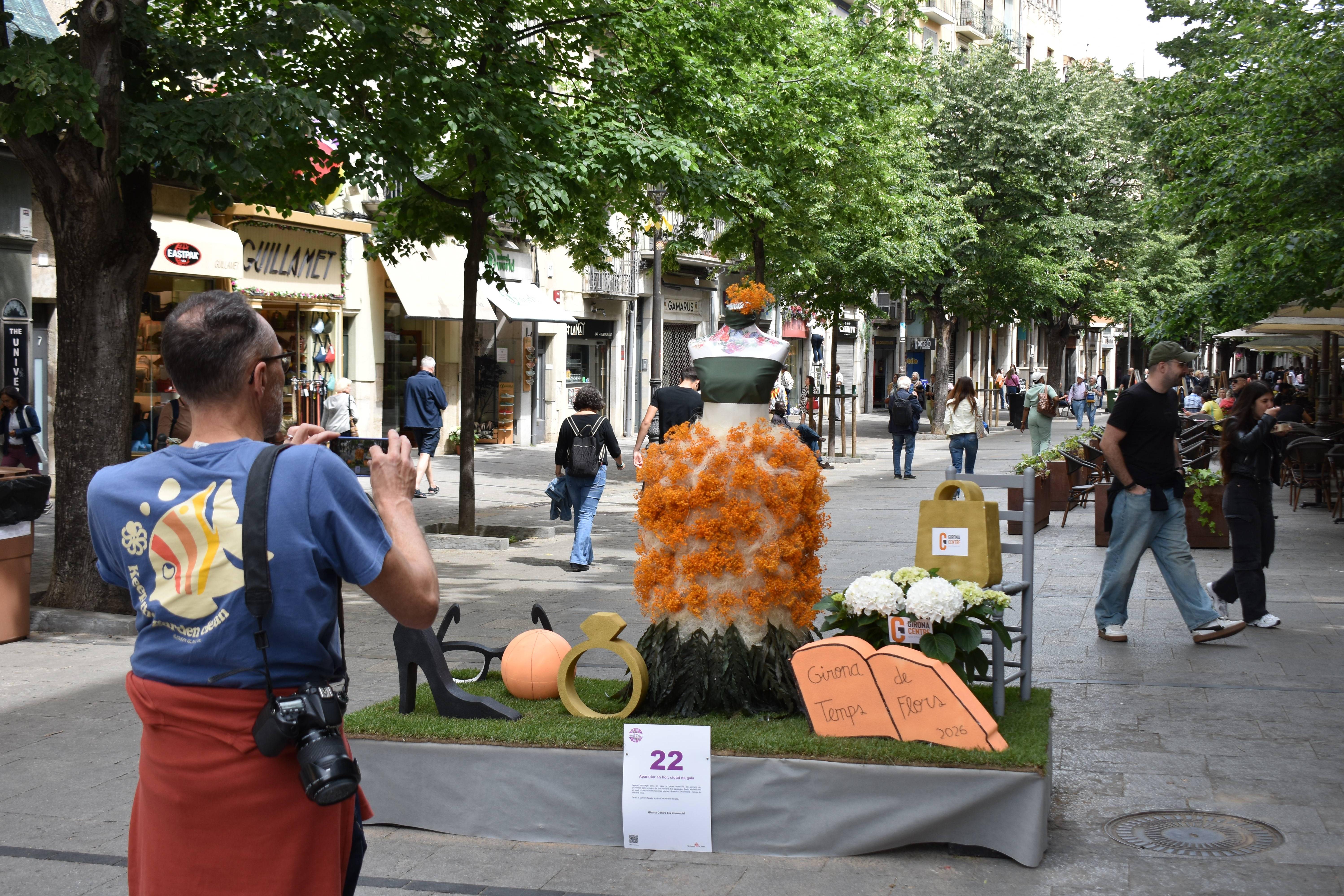 Muntatge Tempsd e Flors a la Rambla. Un visitant hi fa una foto.