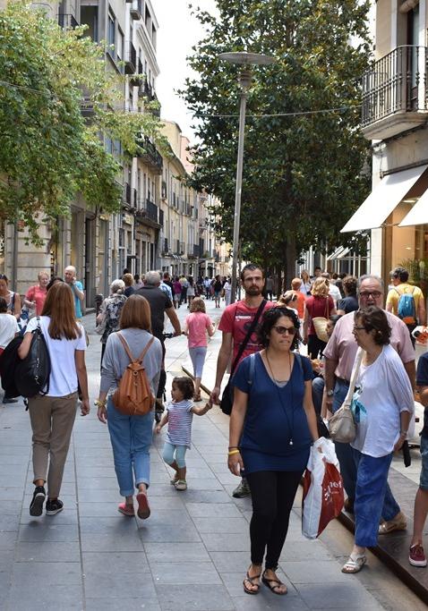 gent passejant per un carrer comercial