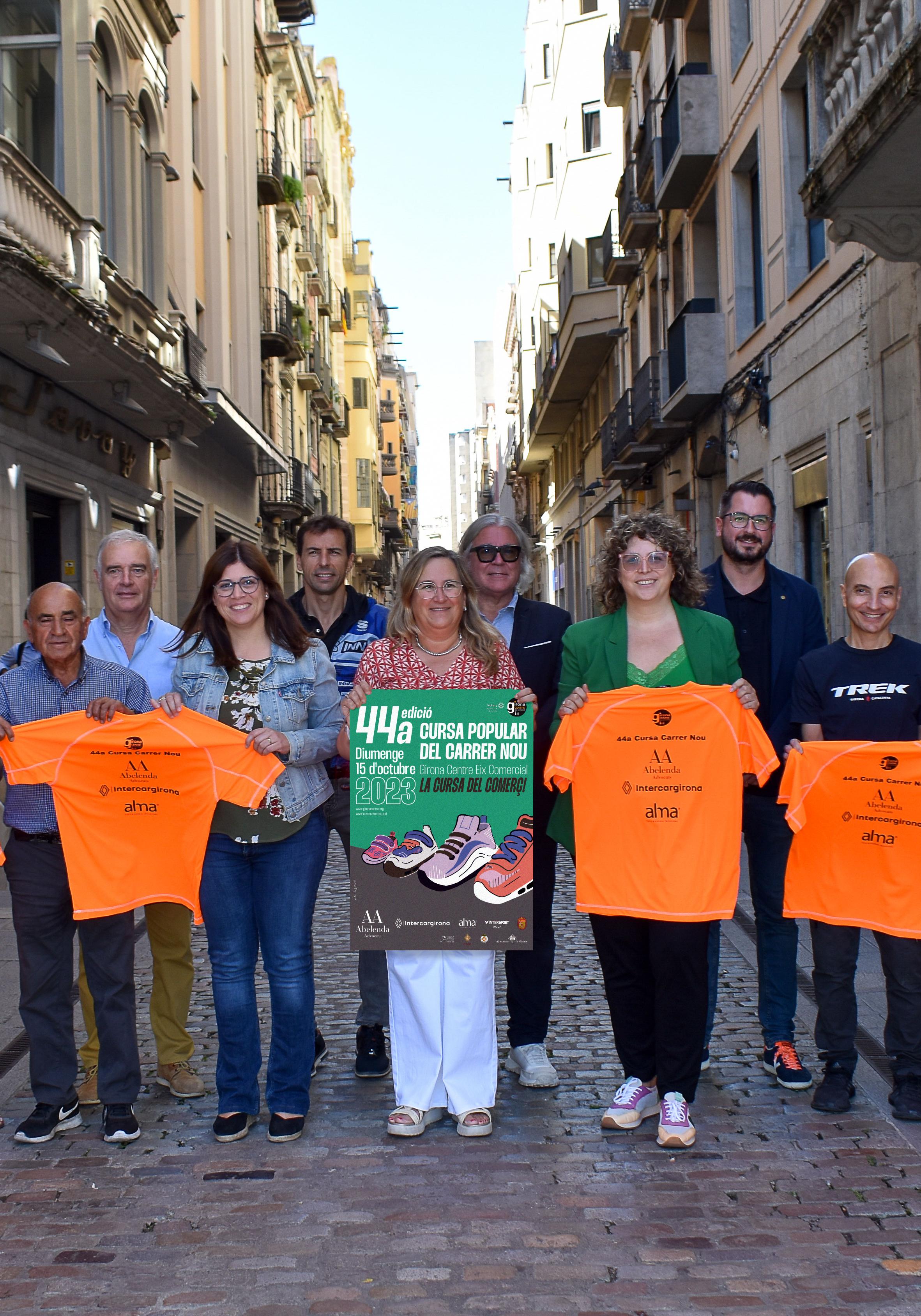 Organitzadors i col·laboradors de la cursa mostren al carrer el cartell i la samarreta 2023