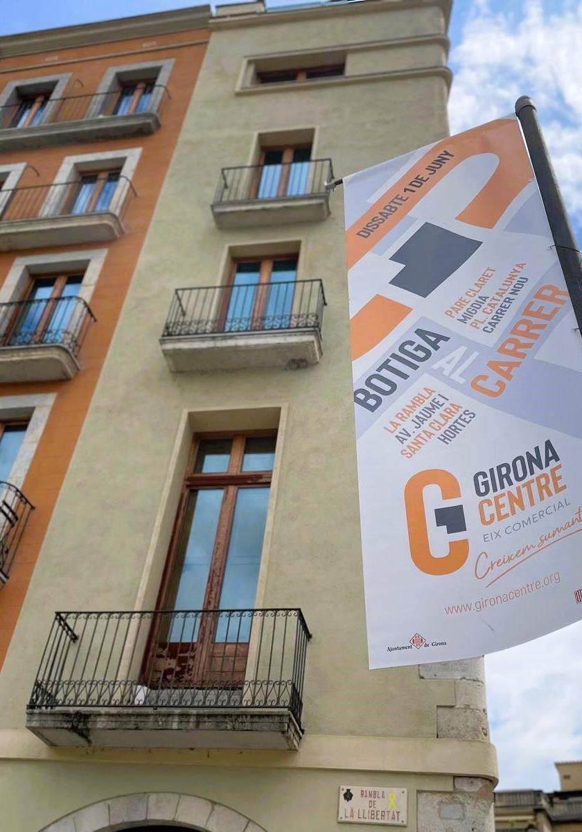 Banderola al carrer anunciant la botiga al carrer