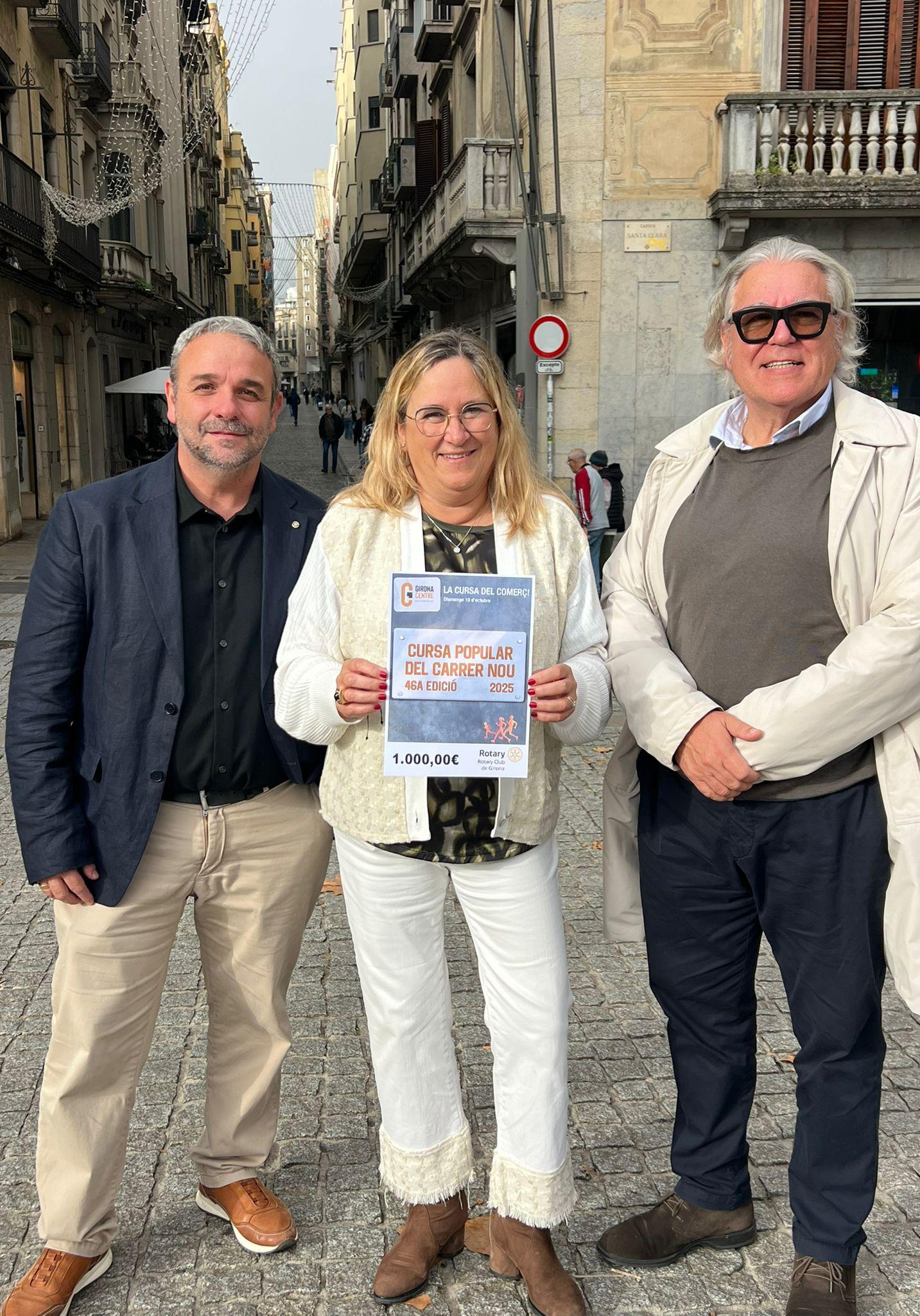 Els representants de Girona Centre Eix Comercial i el Rotary Club mostren el xec solidari