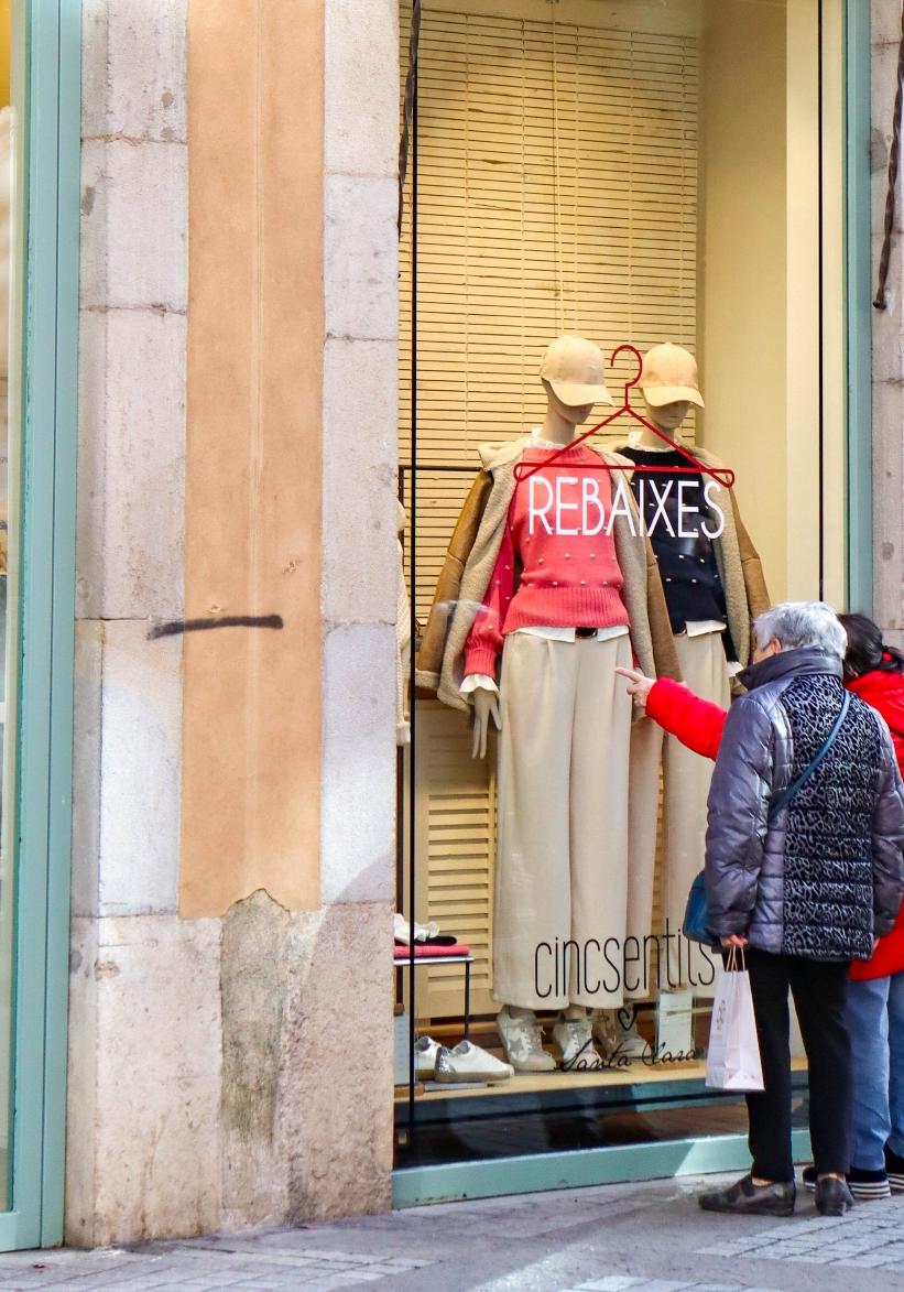 Persones mirant un aparador en rebaixes