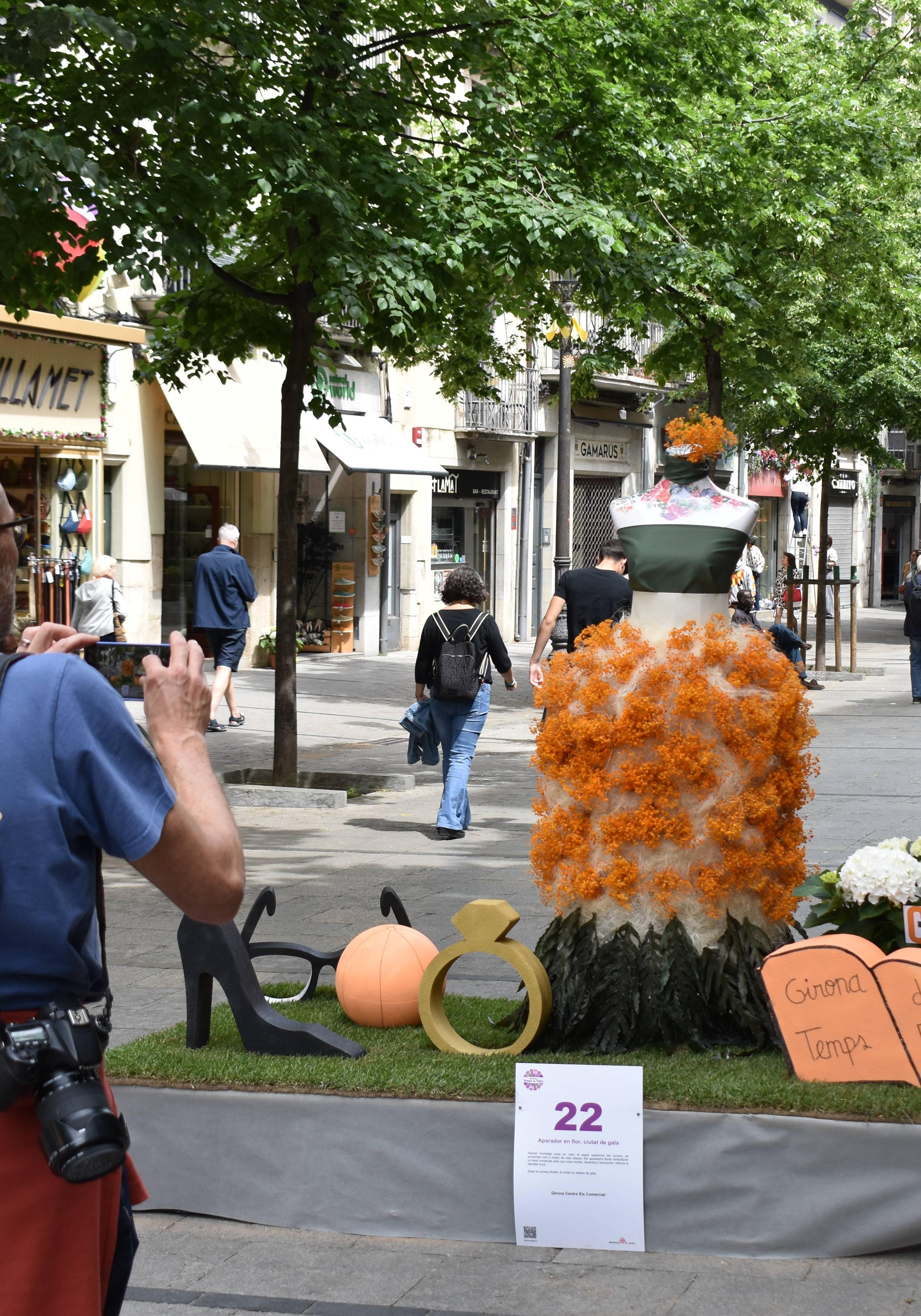 Muntatge Tempsd e Flors a la Rambla. Un visitant hi fa una foto.