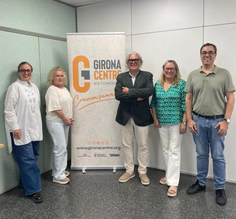 Cinc persones amb roll up corporatiu mirant a càmera